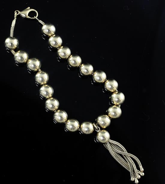 An 18ct gold bead bracelet with tasselled drop, 18cm